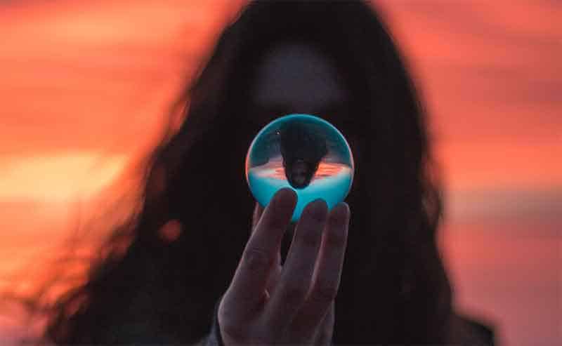 A person holding an clear sphere