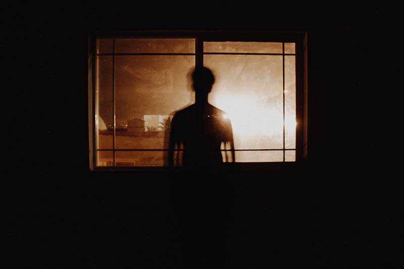 A person standing behind a window