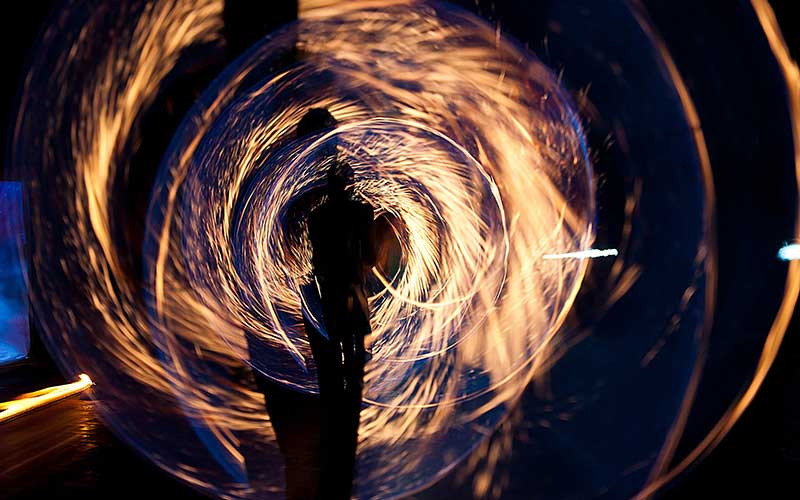 A person inside a circle of sparks