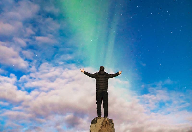 A person standing on top of a rock