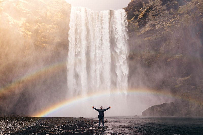 A person standing in front of a waterfall