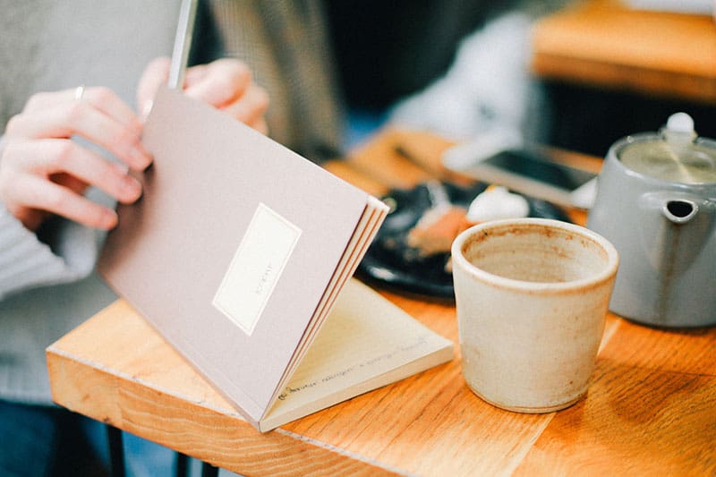 A notebook and coffee mug sitting on a table