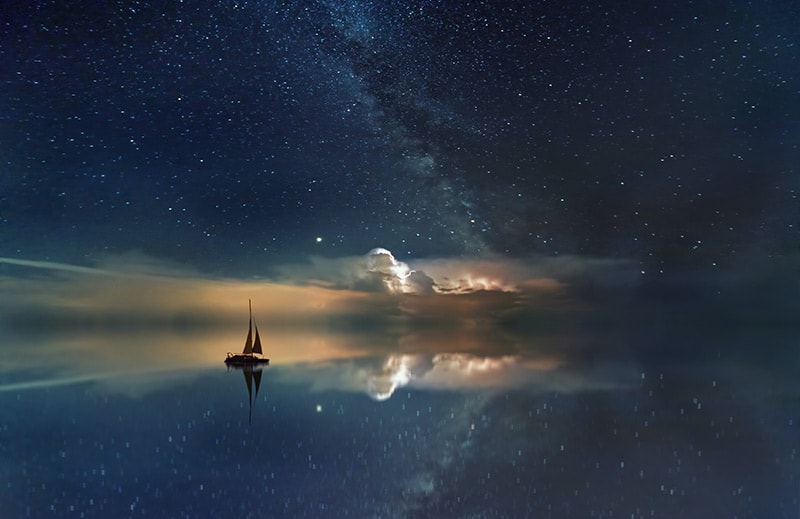 A drawing of a boat on water with stars above
